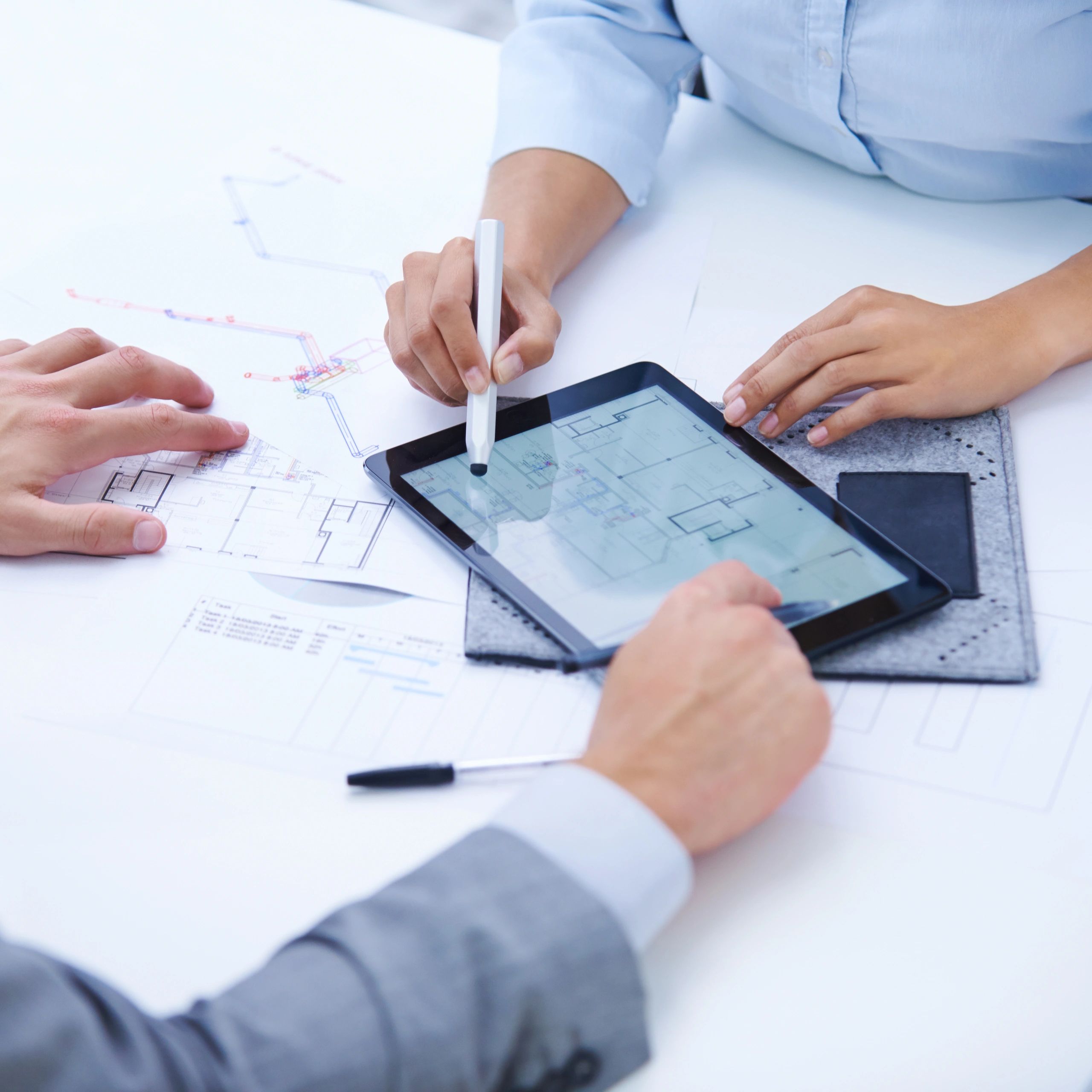 Team reviewing architectural plans on a tablet and blueprints